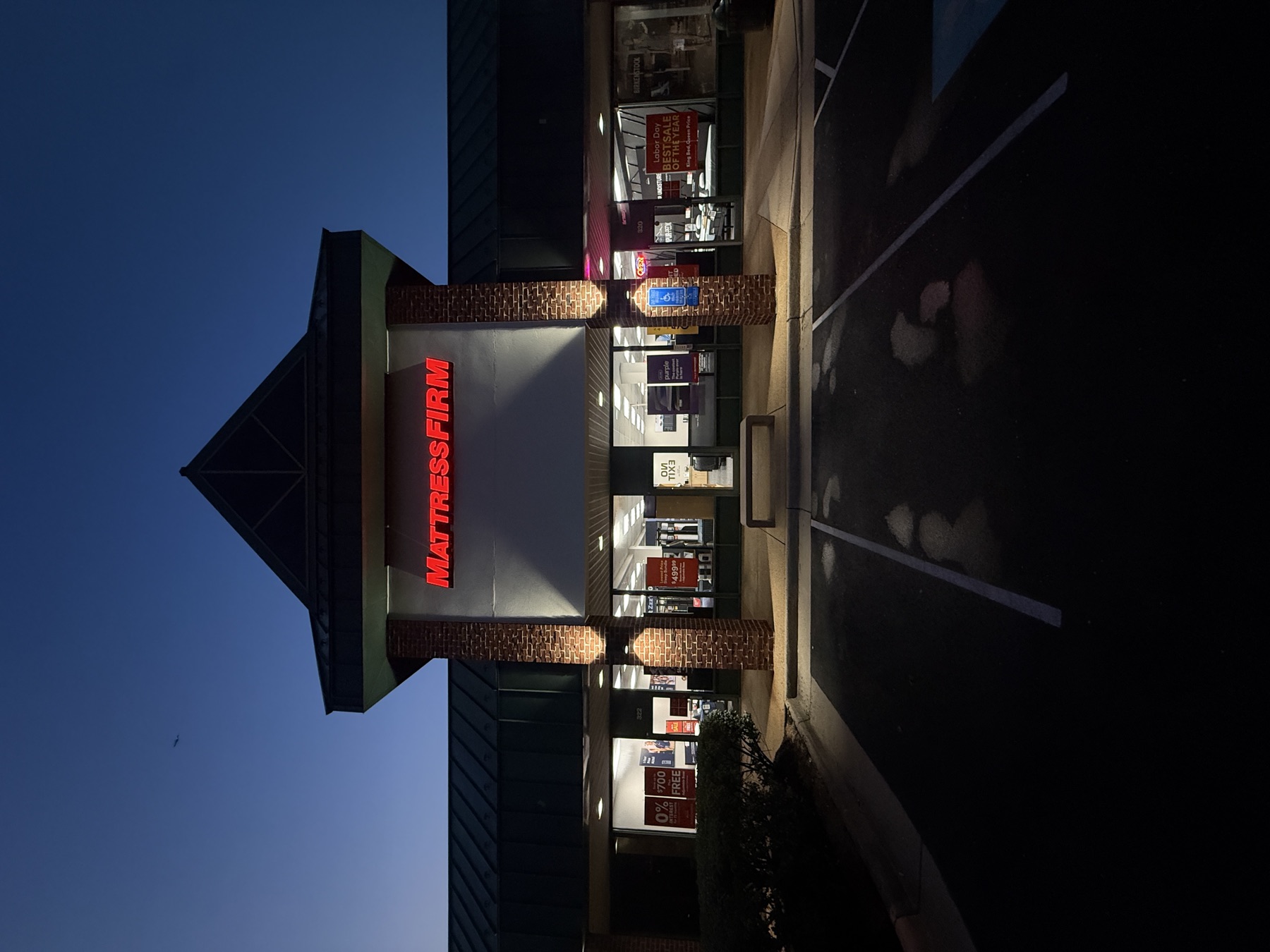 Illuminated channel letters glowing at dusk above a retail entrance