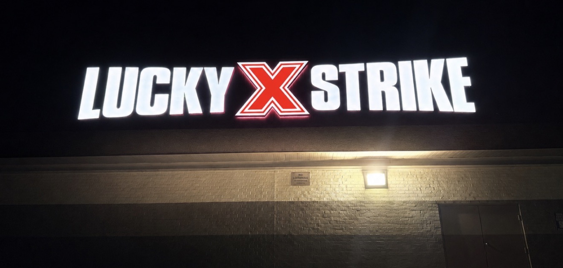 Illuminated channel letters on a commercial facade at night