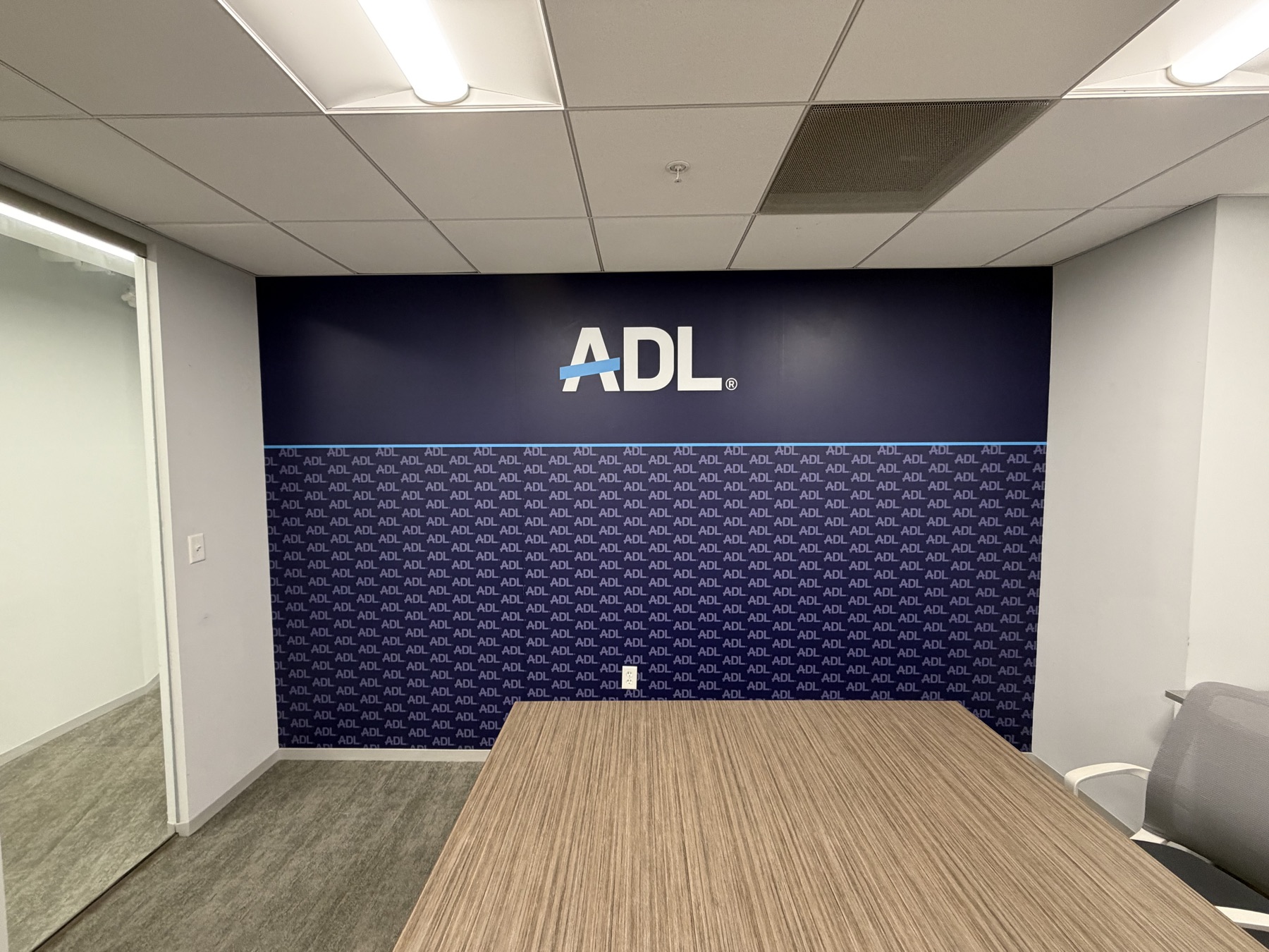 Branded wall wrap installed in a corporate conference room