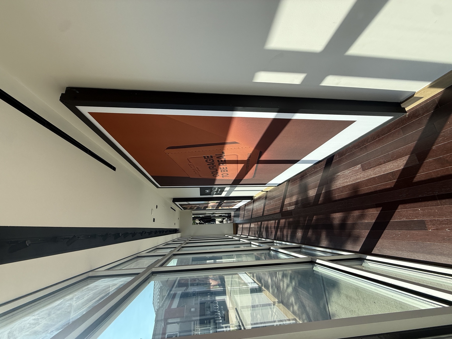 Ceiling-hung backlit lightboxes installed over a retail display
